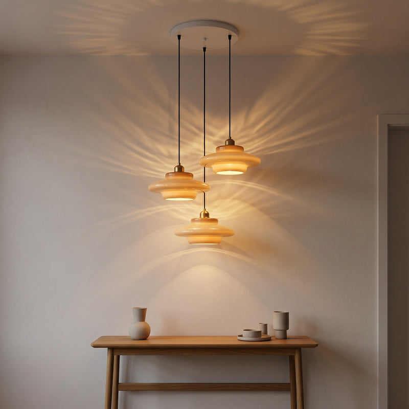 Suspension Nacre, avec un jeu de lumière au mur, allumée