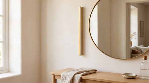 Applique Trait dorée posée à côté d'un miroir dans une entrée claire