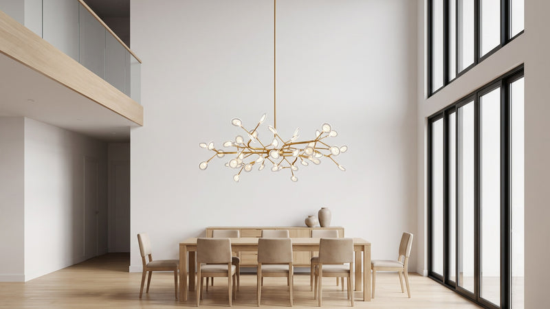 Lustre Lucioles doré suspendu au-dessus d'une table dans une pièce en double hauteur
