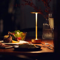 Lampe chevet aluminium champagne sur bureau, ambiance tamisée