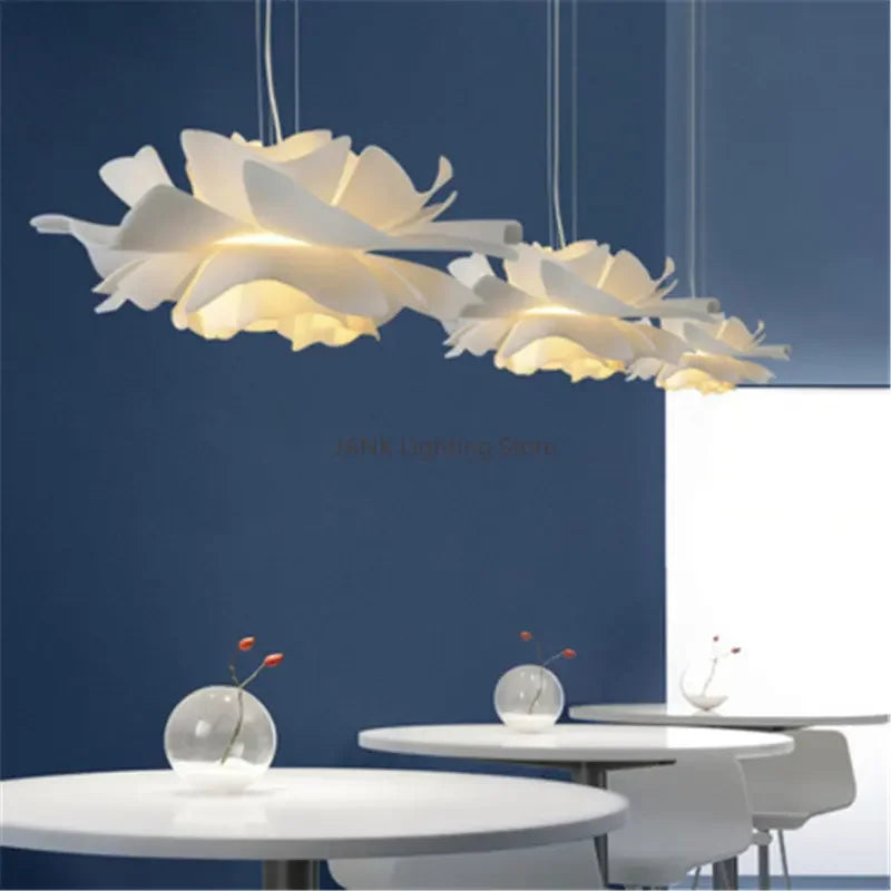 Lustre crème allumé en blanc chaud au-dessus d'un lit double feutré