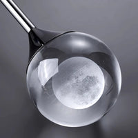 Suspension luxe créative G9, vue trois quarts du luminaire éteint jeu de lumière naturel