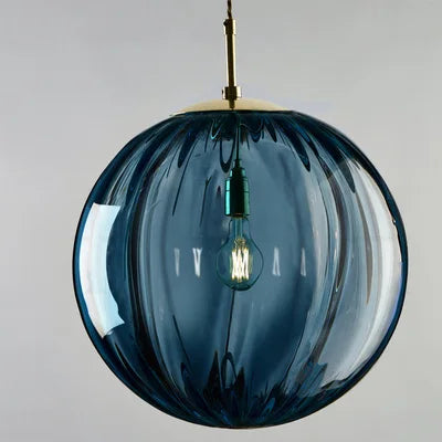 Suspension boule verre marron allumée, halo doux en ambiance