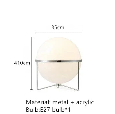 Lampadaire doré boule blanche allumé près d'un canapé velours