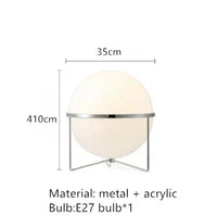 Lampadaire doré boule blanche allumé près d'un canapé velours