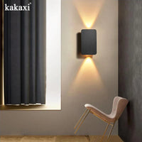 Applique LED grise au-dessus d'un chevet scandinave épuré