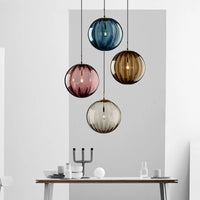 Suspension boule verre bleu 20 cm au-dessus d'une table en bois