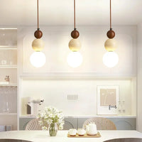 Lustre cream pierre bois Bauhaus E14, ambiance soir au-dessus d'une table ambiance chaleureuse