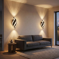 Applique Flamme coloris noir, avec un jeu de lumière au mur, allumée