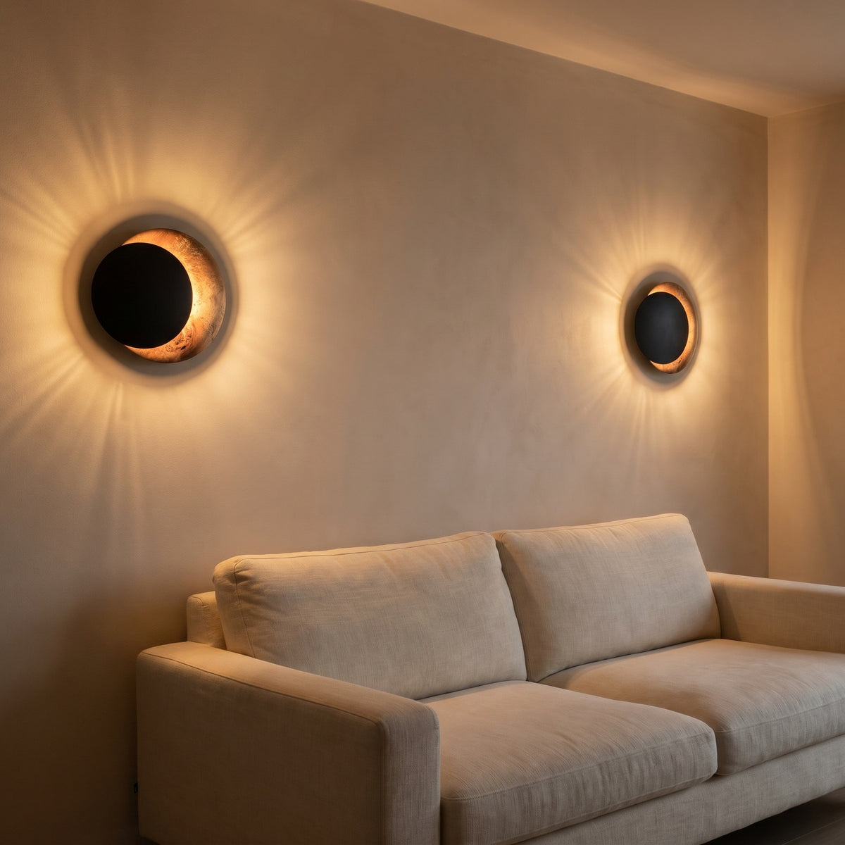 Applique Aurore coloris cuivre noir, avec un jeu de lumière au mur, allumée