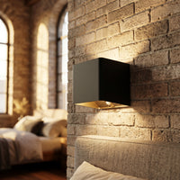 Applique murale LED détecteur de mouvement coloris noir, dans un loft de brique élégant, allumée